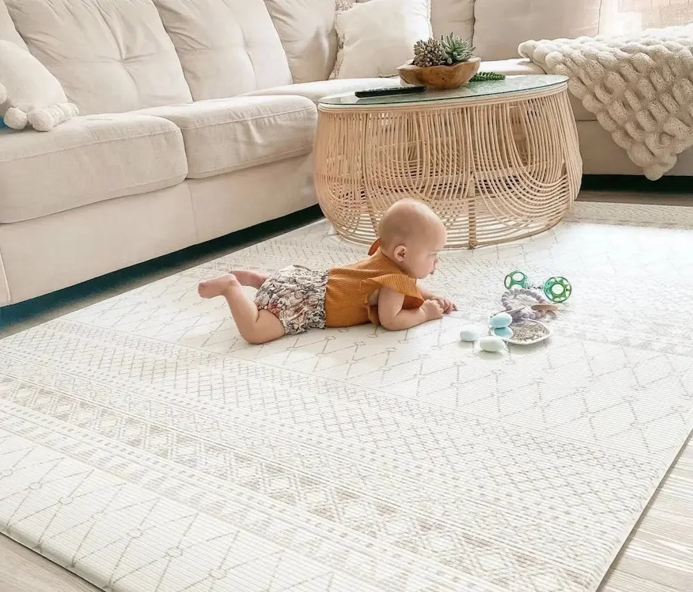 Bébé en position Tummy Time sur un tapis d'éveil pour renforcer sa musculature cervicale.