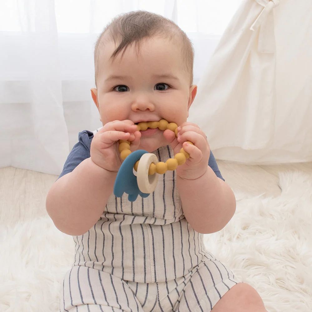 Bébé tenant un anneau de dentition en silicone coloré