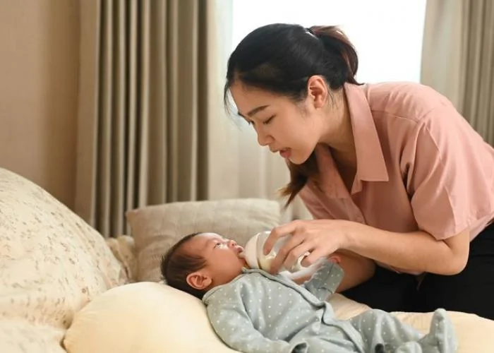 Maman donnant un biberon anti-colique à son bébé dans une position semi-inclinée