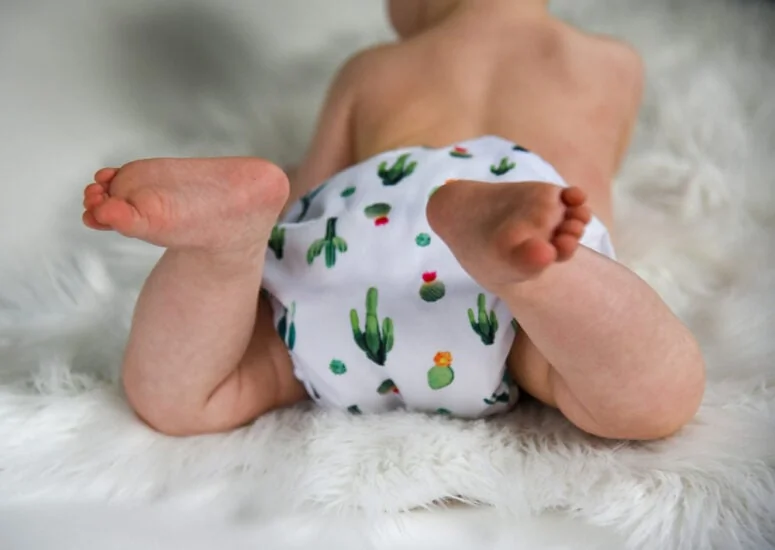 Bébé portant une couche lavable colorée sur une table à langer