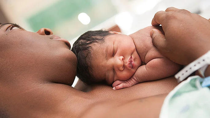 Maman tenant son nouveau-né en peau à peau juste après un accouchement naturel
