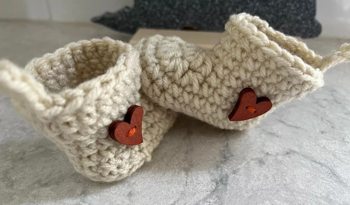 Grands-parents émus découvrant des petits chaussons pour une annonce grossesse originale.