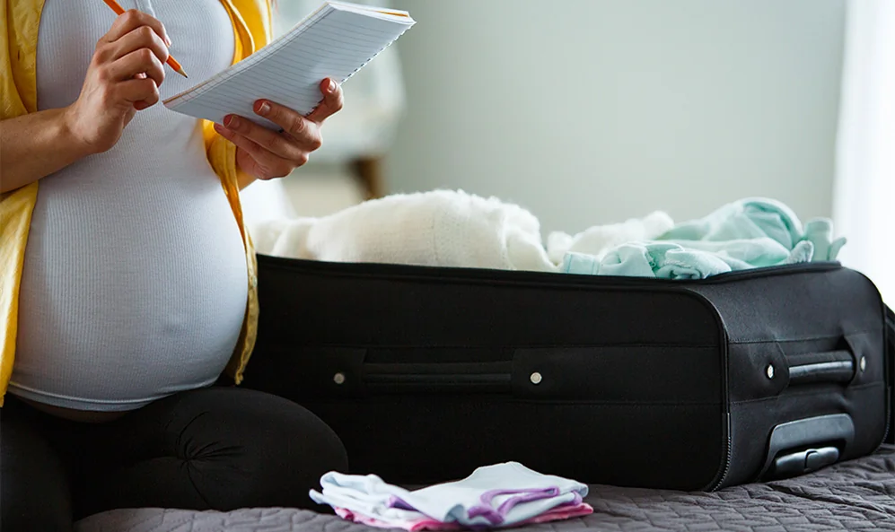 Vêtements et accessoires pour bébé étalés sur un lit