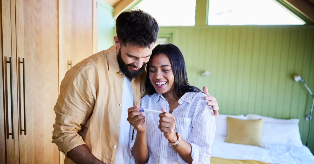 Couple regardant le résultat d'un test de grossesse avec émotion