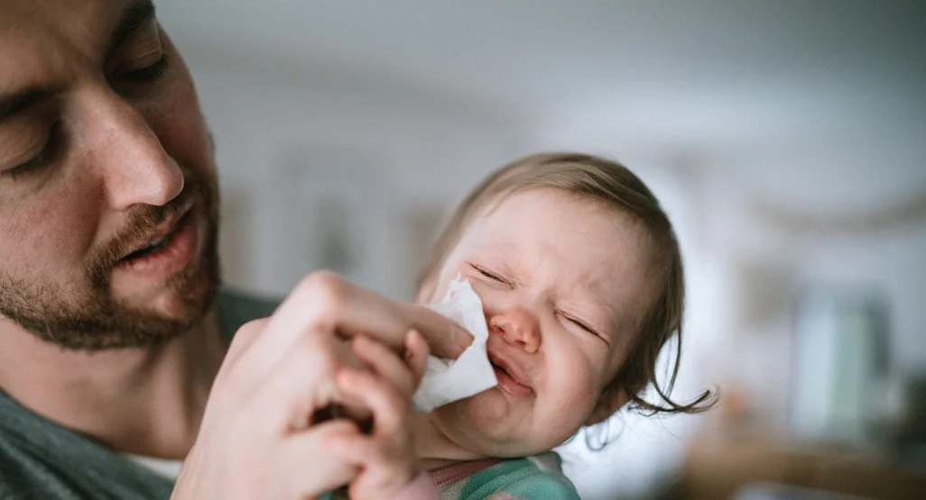 Nourrisson avec le nez qui coule, premier symptôme de la bronchiolite bébé