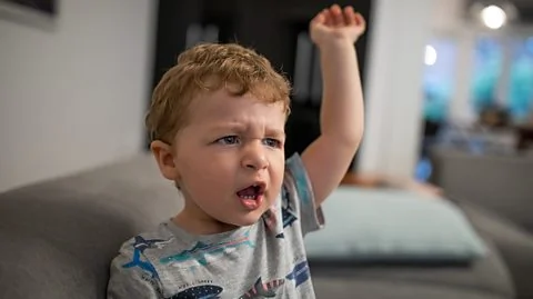 Petit garçon exprimant une forte frustration lors d'une crise de colère typique des 2 ans