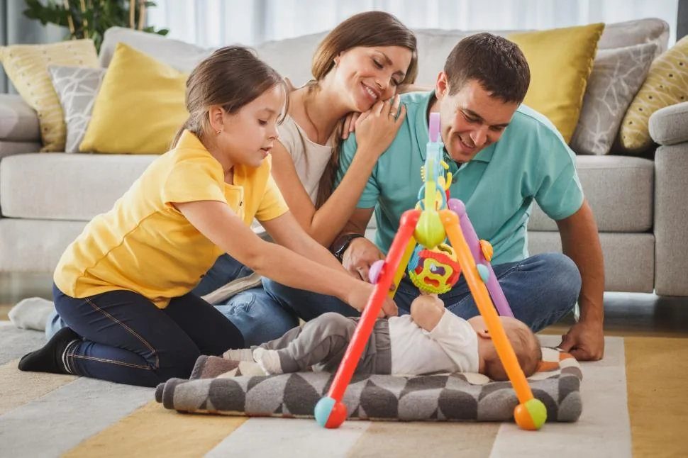 Père et bébé jouant ensemble, profitant du nouveau congé de naissance 2026.