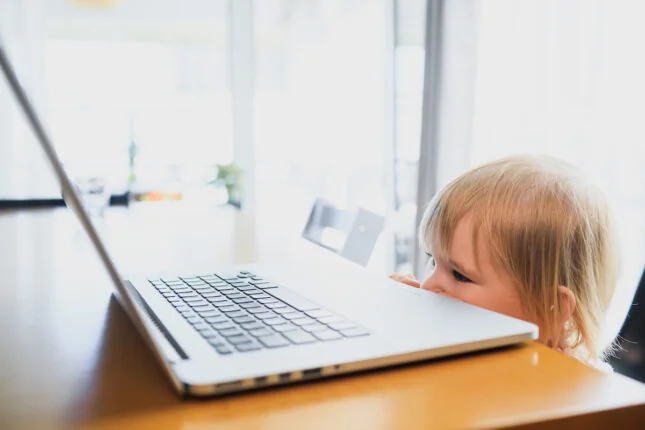 Parent inquiet vérifiant les références d'une baby-sitter sur son ordinateur