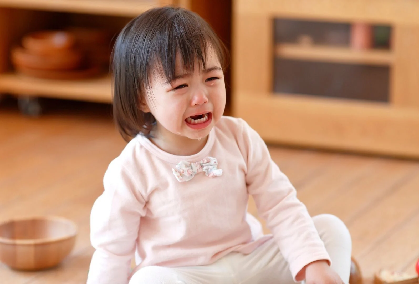 Enfant en pleine crise de colère allongé sur le sol, illustrant la difficulté de gérer ses émotions