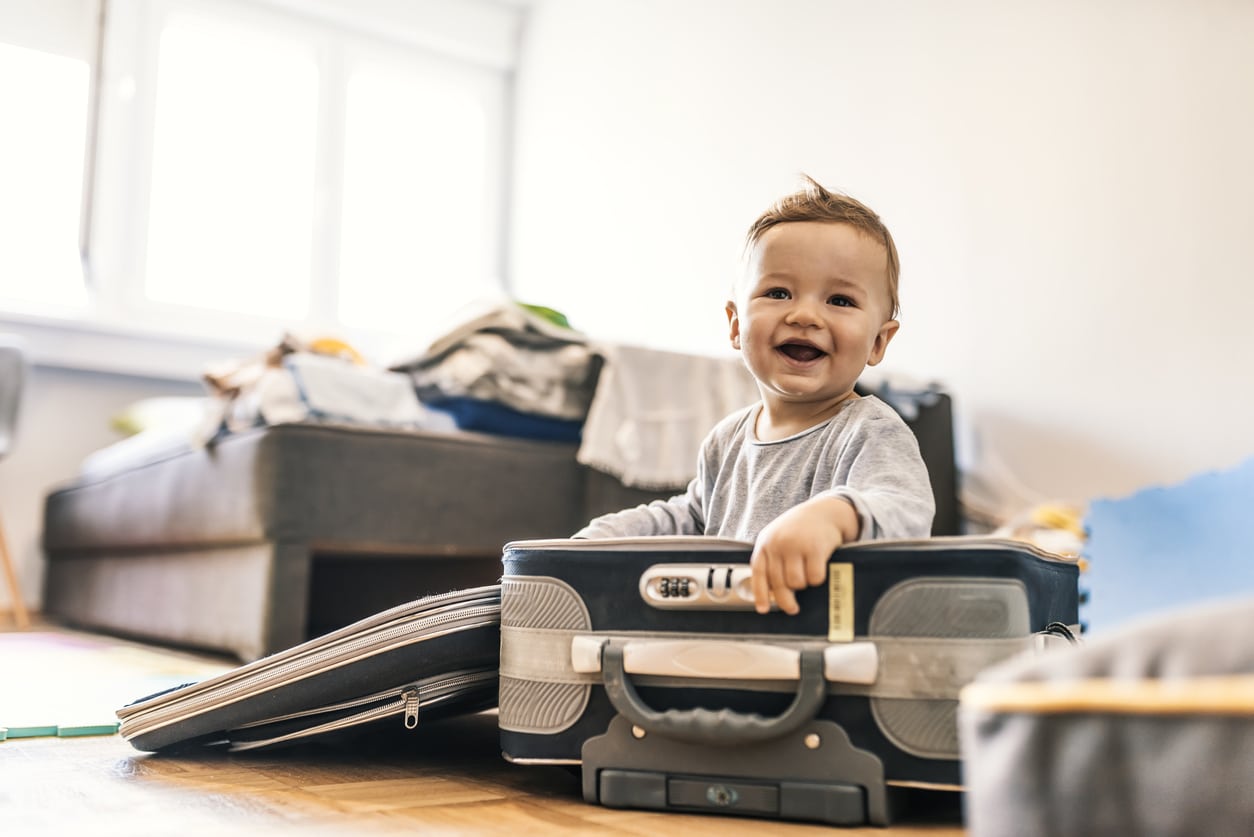Bébé souriant assis dans une valise
