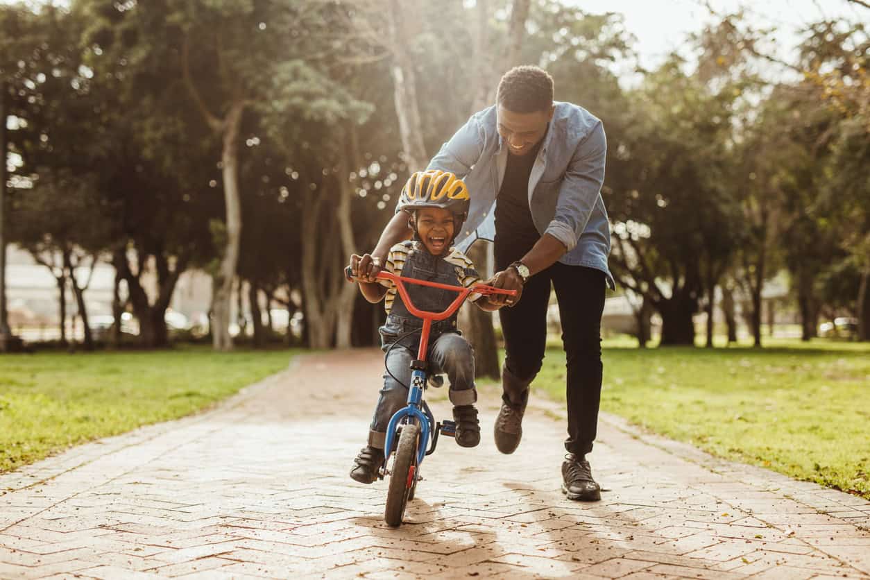 Père apprenant à son fils à faire du vélo