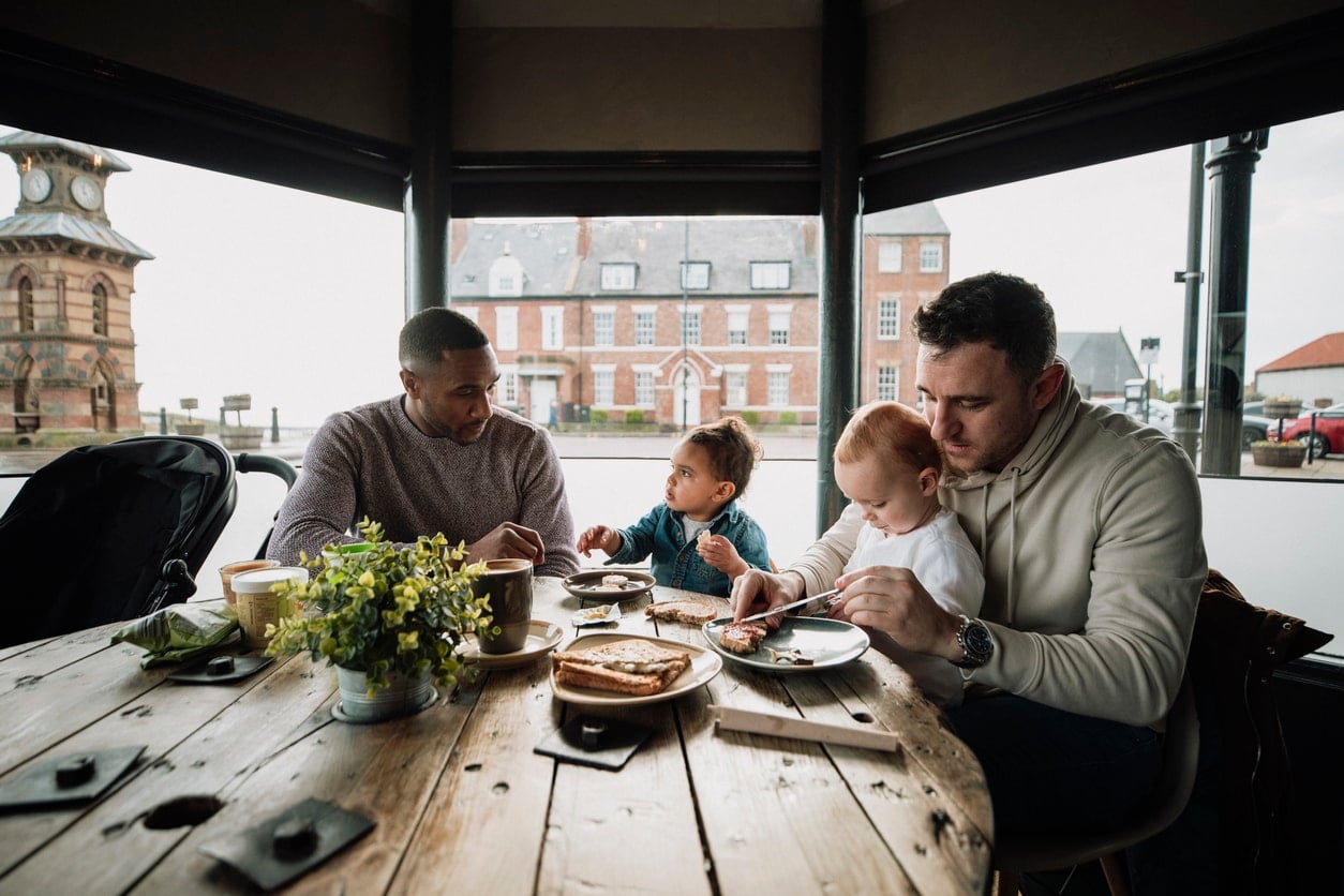 Papas discutant dans un café avec leurs bébés