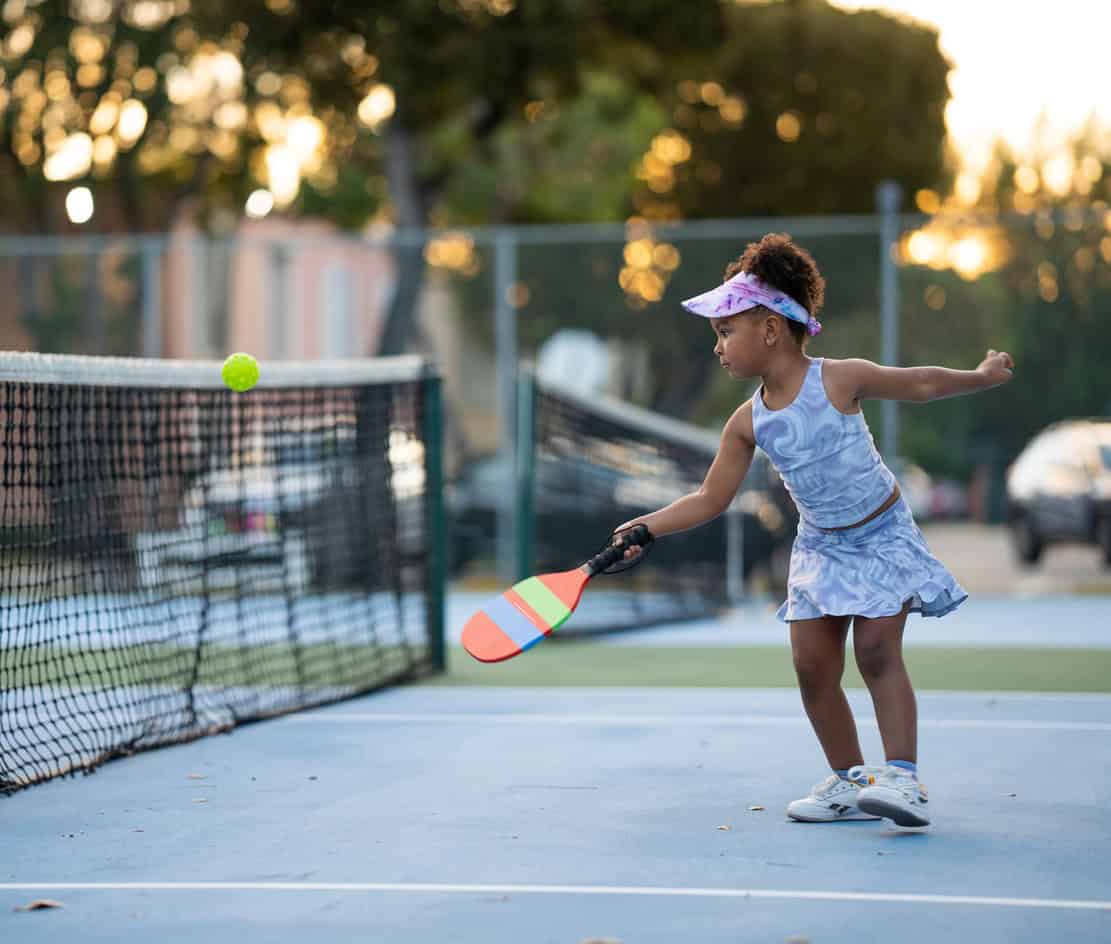 Petite fille jouant au pickleball en extérieur