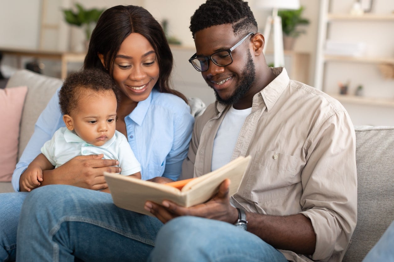 Parents lisant un livre avec leur bébé