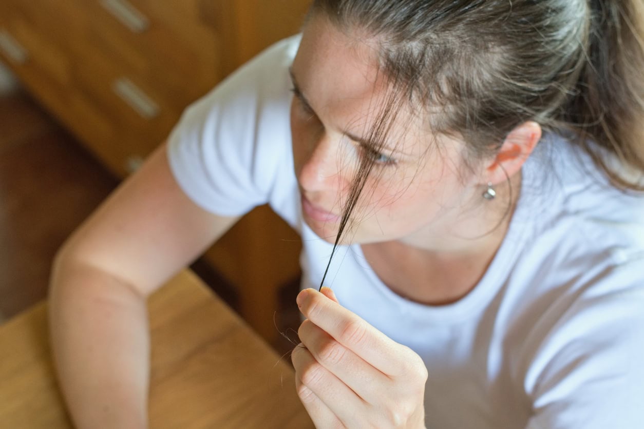Maman se touchant les cheveux clairsemés