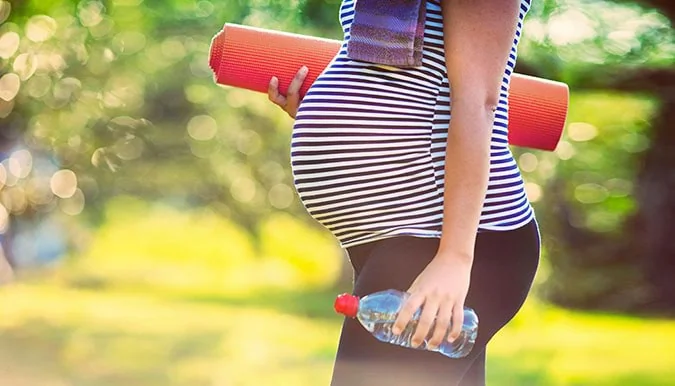 Femme enceinte pratiquant des étirements doux en extérieur