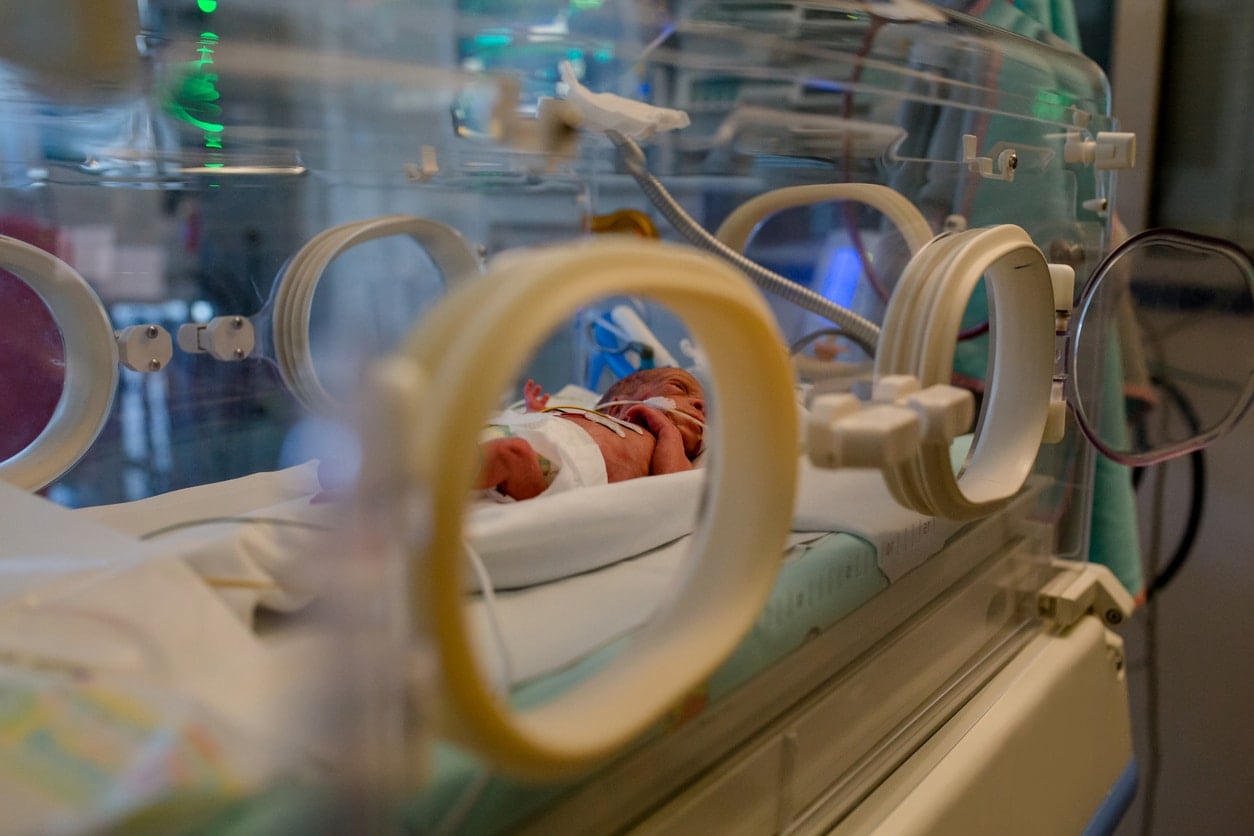 Bébé prématuré en couveuse avec capteurs de surveillance