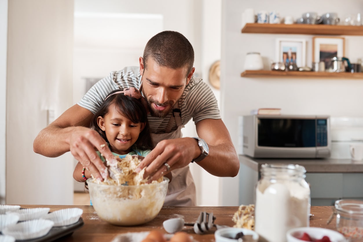 Un homme cuisinant avec sa petite fille