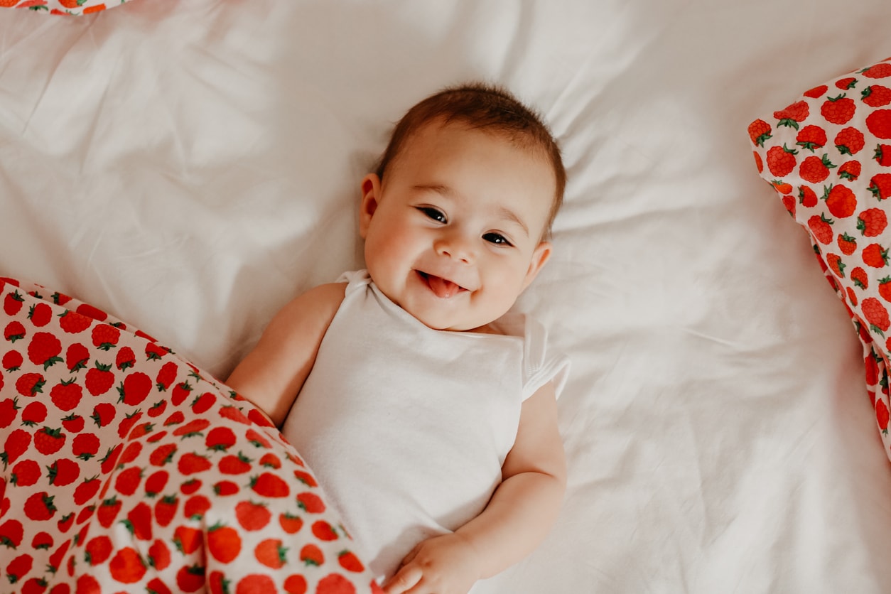 Bébé fille souriante allongée sur une couverture