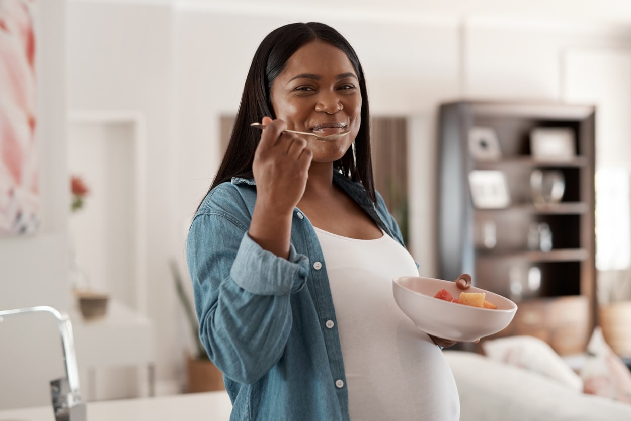 Femme enceinte mangeant des fruits