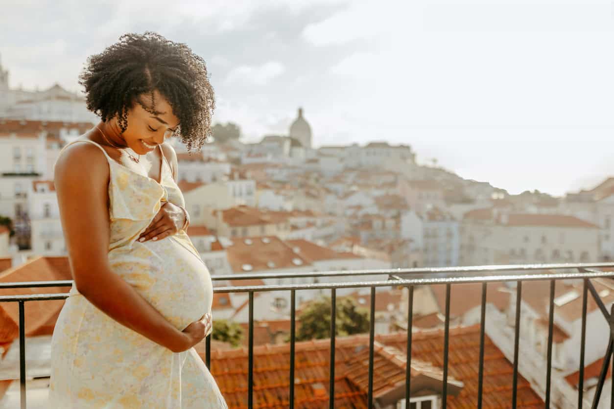 Future maman souriante profitant d'un voyage prénatal