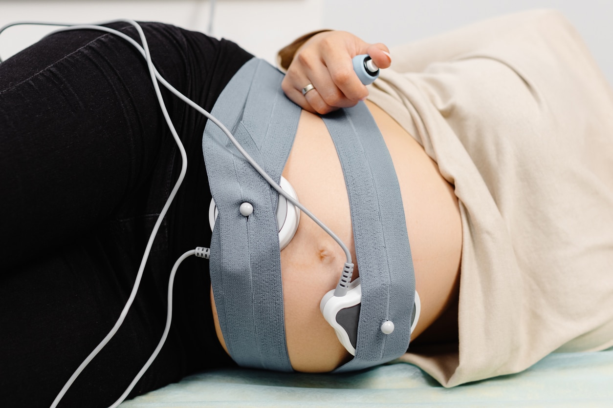 Femme enceinte passant un monitoring fœtal avec une sage-femme