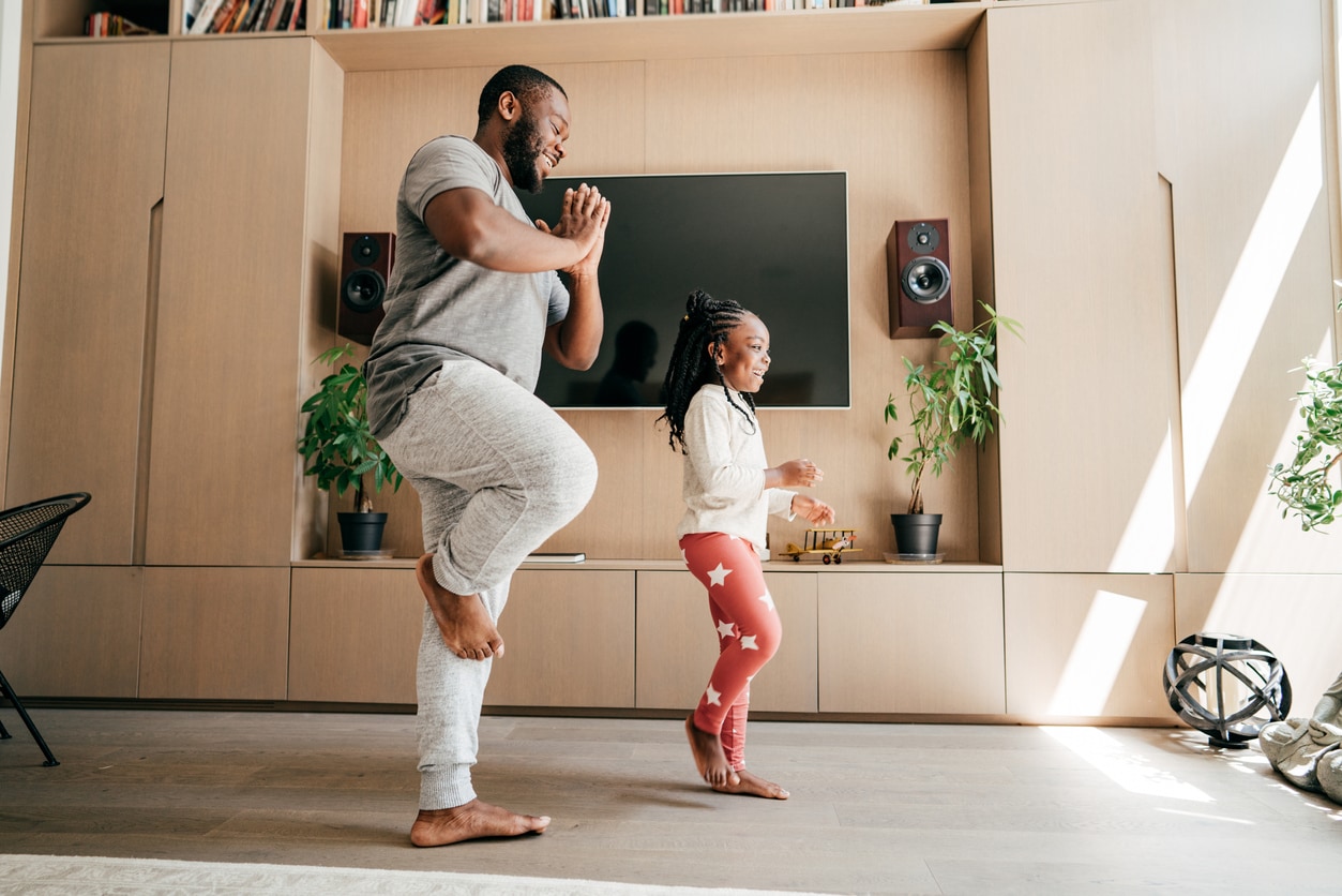 Un père et sa fille pratiquant le yoga ensemble à la maison