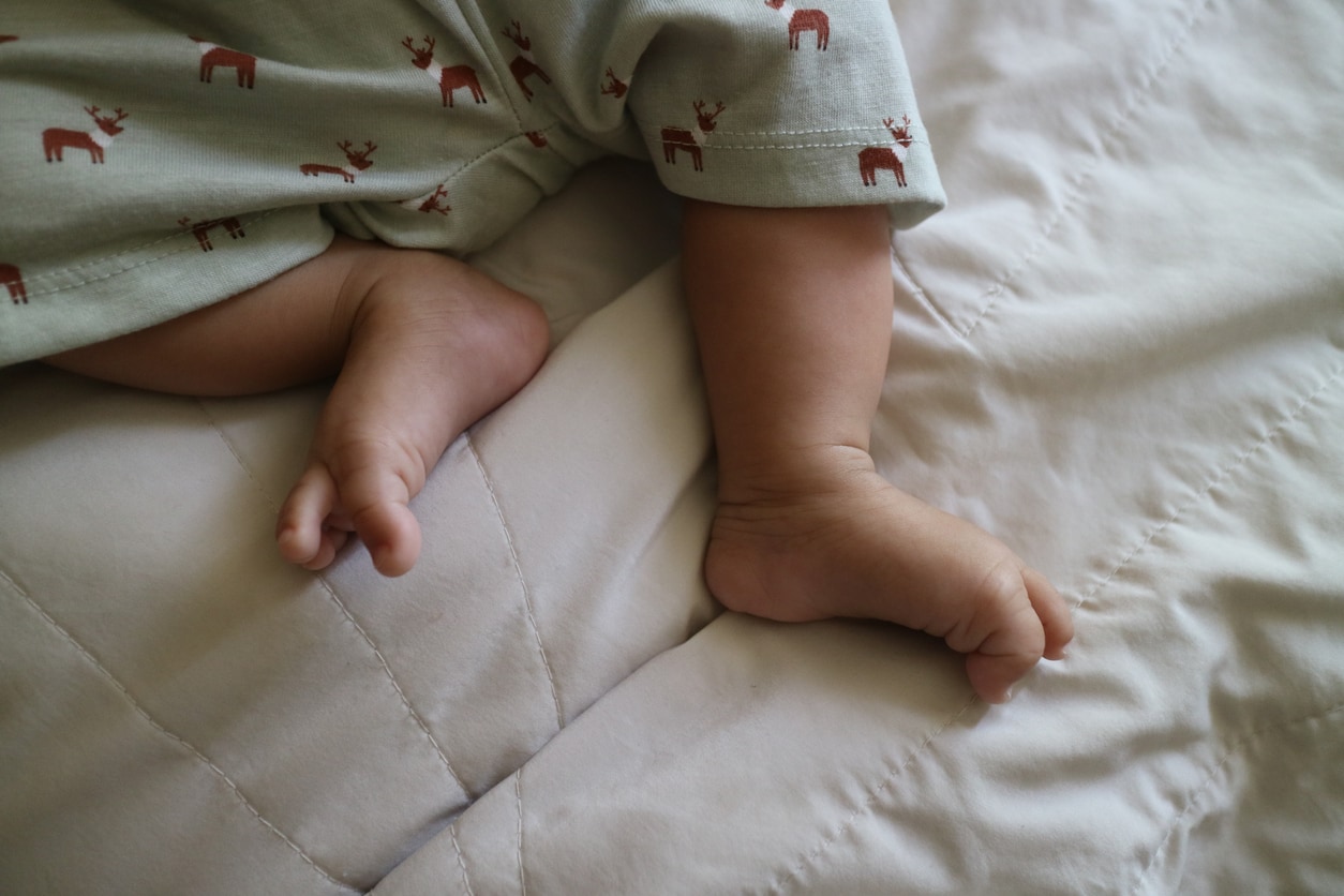 Pieds d'un nourrisson sur un matelas blanc