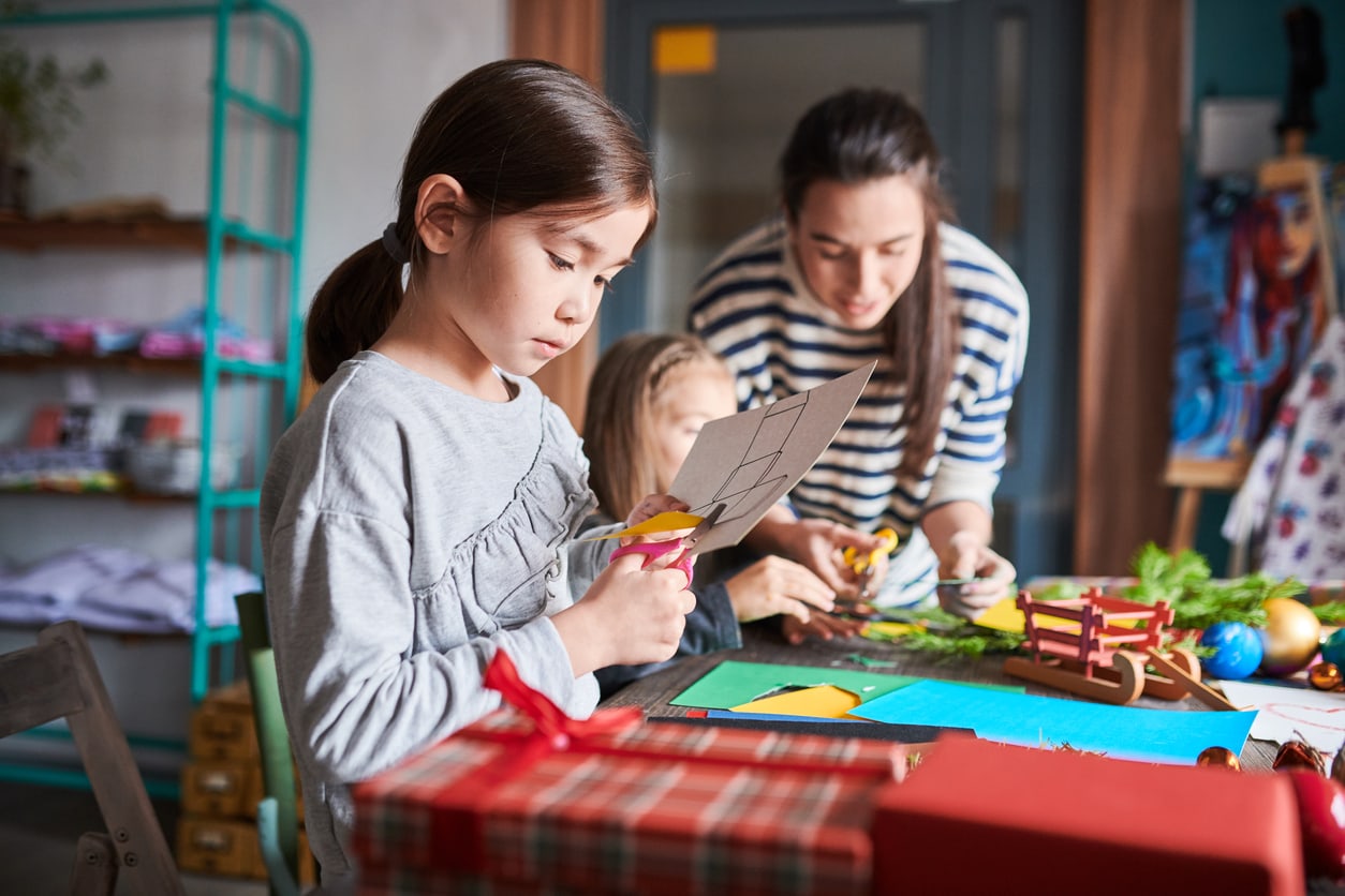 Petite fille fabriquant des cartes de Noël à la main