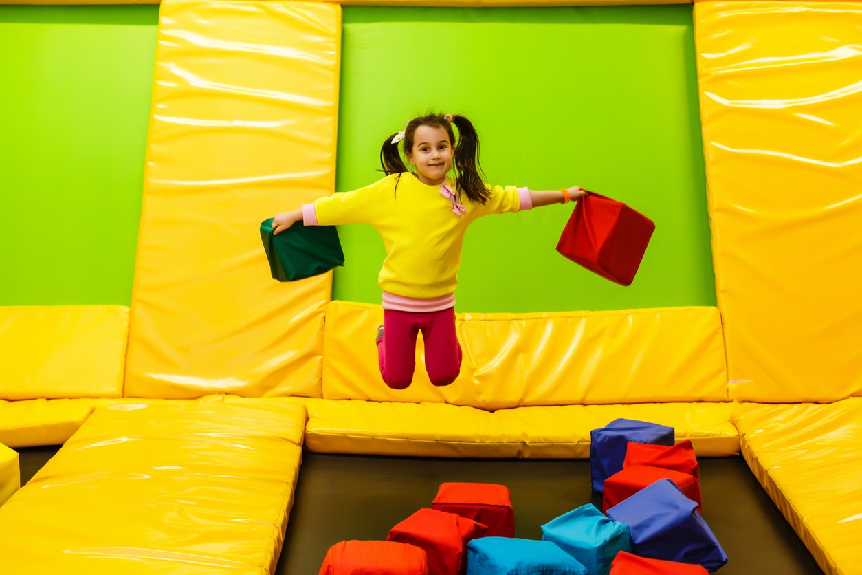 Fille sautant dans un parc à trampolines intérieur