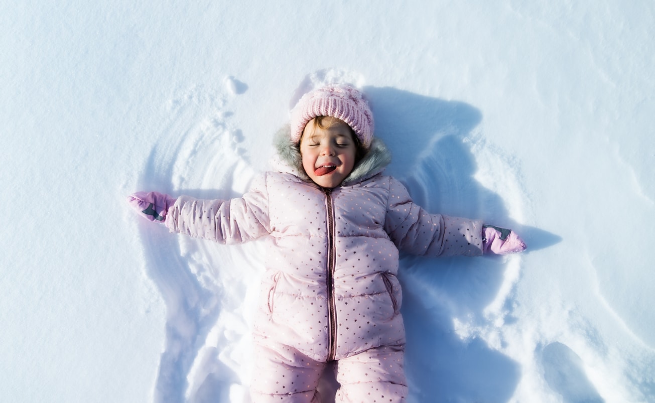 Petite fille faisant un ange dans la neige