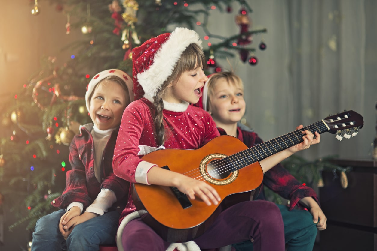 Enfants portant des bonnets de Père Noël et chantant