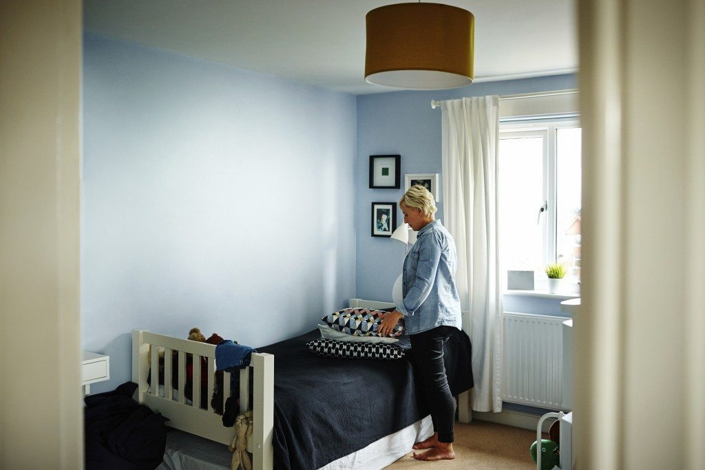 Femme enceinte rangeant des coussins