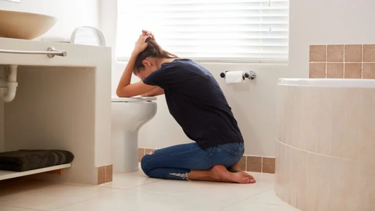 Femme enceinte souffrant de nausées matinales assise sur son lit