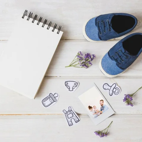 Préparation minutieuse d'une liste de naissance avec des vêtements et accessoires pour bébé