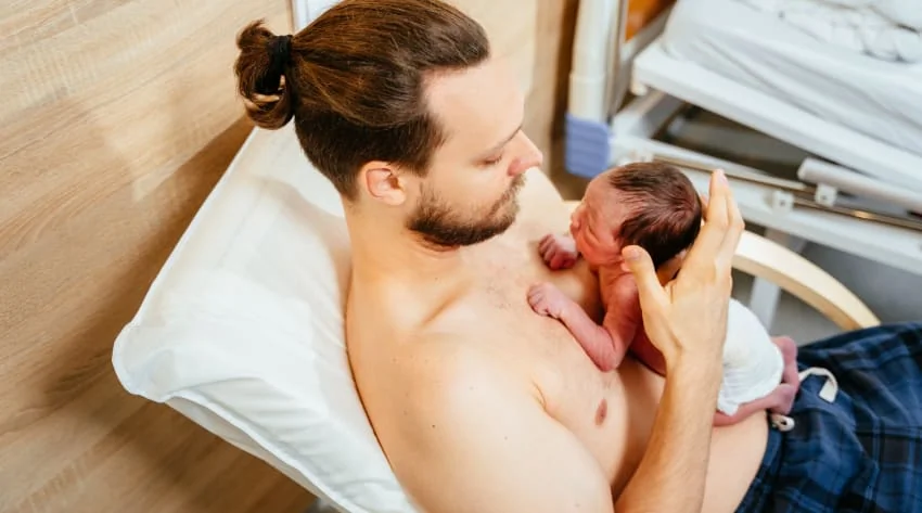 Père pratiquant la méthode kangourou avec son bébé prématuré en contact peau à peau.
