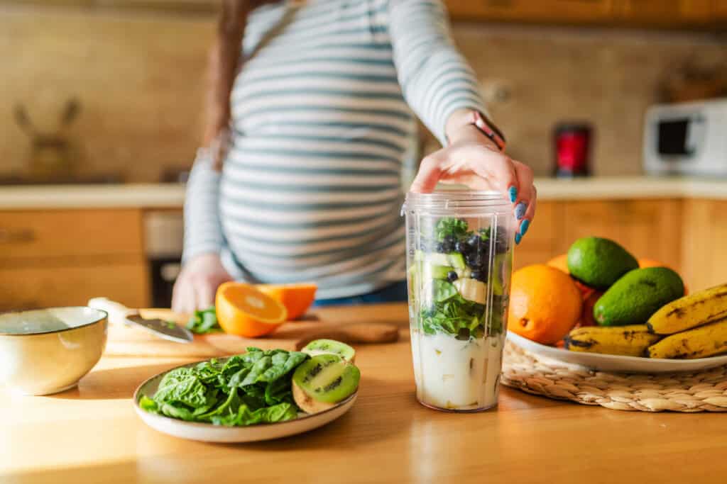Femme enceinte préparant un smoothie sain